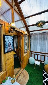 a room with a tv and a room with green carpet at Bawli Treehouse in Jibhi