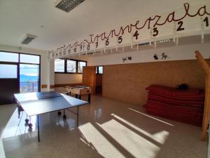 a room with a ping pong table and a sign on the wall at Tau Forest Lodge in Solkan +19 photos