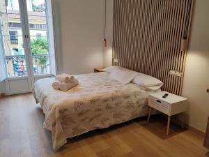 a bedroom with a bed with a night stand and a window at alojamiento premium Ribadesella 2 dorm in Ribadesella