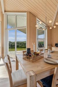 Feriehus 3020 في فيد ساندي: غرفة طعام مع طاولة خشبية مع كراسي
