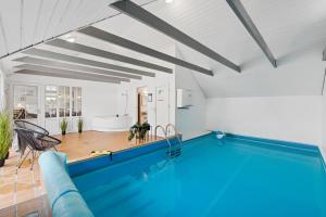 a swimming pool in a living room with a house at Feriehus 1145 in Ringkøbing