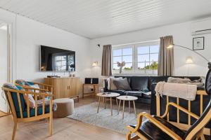 Feriehus 1145 في سوندرفيغ: غرفة معيشة مع أريكة وكراسي سوداء