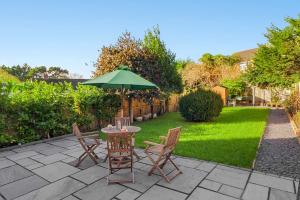 a patio with a table and chairs and an umbrella at Exeter Heights - Short Stays UK Ltd in Exeter