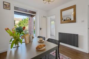 a dining room with a table and a vase of flowers at Exeter Heights - Short Stays UK Ltd in Exeter +33 photos