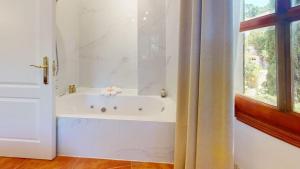 a white bath tub in a bathroom with a window at Villa Valmores in Olmeda de las Fuentes +31 photos