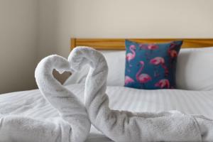 two towel swans making a heart on a bed at Exeter Heights - Short Stays UK Ltd in Exeter