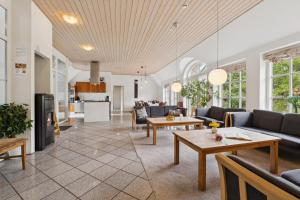 Feriehus 2020 في Øby: غرفة معيشة مع كنب وطاولات ومطبخ