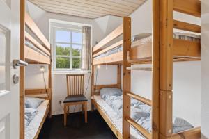 Feriehus 2020 في Øby: غرفة بها أربعة أسرة بطابقين وكرسي +27 صورة