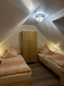 een slaapkamer met 2 bedden en een kroonluchter bij Haus Maria am Meer in Göhren