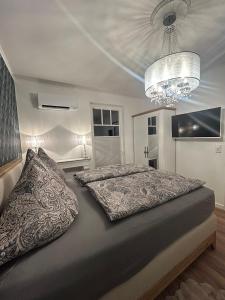 een slaapkamer met een groot bed en een kroonluchter bij Haus Maria am Meer in Göhren