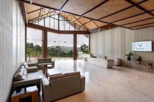 Osian Valley Resort & Spa Kumbhalgarh في Jāmb: ردهة كبيرة مع أرائك وطاولات ونوافذ