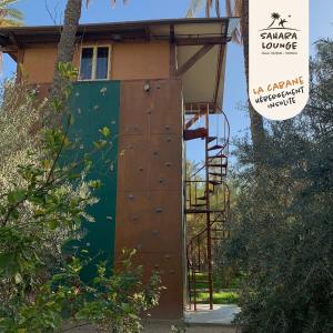 a building with a wooden door and a ladder at Sahara Lounge in Tozeur
