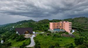 Osian Valley Resort & Spa Kumbhalgarh في Jāmb: اطلالة جوية على فندق على تلة