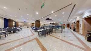 a restaurant with tables and chairs in a room at Al Ansar Platinum Hotel فندق الأنصار بلاتينوم in Medina