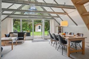 a conservatory with a dining room and living room at Feriehus 1133 in Ringkøbing