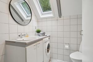 a bathroom with a sink and a washing machine at Feriehus 1133 in Ringkøbing