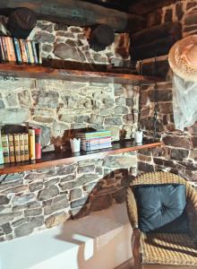 a stone wall with a chair and books on it at Luna Menguante in La Viliella