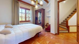 une chambre avec un lit blanc et un escalier dans l'établissement Villa Valmores, à Olmeda de las Fuentes 25 autres photos