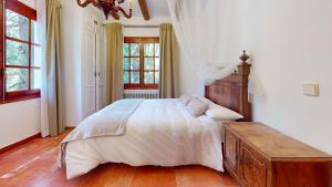 - une chambre avec un grand lit et une commode en bois dans l'établissement Villa Valmores, à Olmeda de las Fuentes