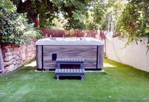 un banc dans une cour arrière avec un bain à remous dans l'établissement Villa Valmores, à Olmeda de las Fuentes