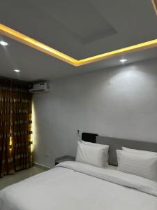 a bedroom with a large white bed with a large ceiling at Modern 3-Bedroom Luxury Home in Lekki Phase 1 in Lekki