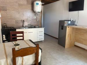 een keuken met een tafel, een wastafel en een koelkast bij CABAÑAS CAMPO y MAR in Playa Dorada