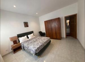 Un dormitorio con una cama y un armario de madera. en Studio, en Saly Niakh-Niakhal