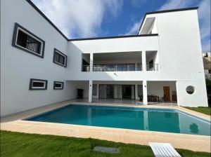 una casa blanca con piscina en Studio, en Saly Niakh-Niakhal
