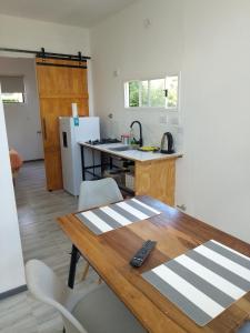 a kitchen with a wooden table with a remote control on it at Tiny House Potrero Cba in Potrero de Garay