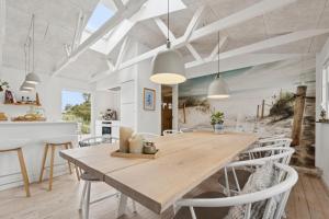 a dining room with a wooden table and chairs at Feriehus 1142 in Ringkøbing