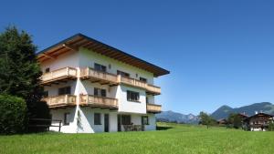 un edificio con balconi in legno su una collina verdeggiante di Wiesennest a Fügenberg