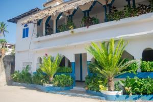 un bâtiment avec des palmiers devant dans l'établissement Mudi House, à Jambiani 70 autres photos
