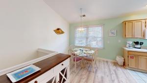 a kitchen with a table and a dining room at Club Villas Unit 17D Villa in Sunset Beach