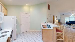 a kitchen with a sink and a refrigerator at Club Villas Unit 17D Villa in Sunset Beach