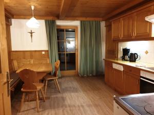 una cocina con una mesa y una cruz en la pared en zuHaus Gruab, en Wildschönau