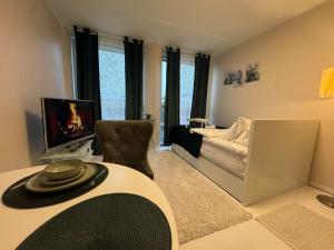 a living room with a table and a tv and a bed at I&A Residence - Roseni tn in Tallinn