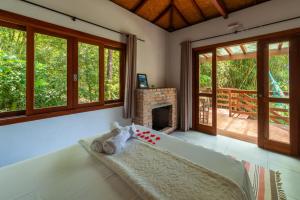 Coração da Terra Praia do Rosa في برايا دو روزا: غرفة نوم بها موقد وسرير في غرفة