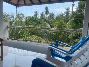 a pair of chairs on a porch with a view of the street at Sedasi Holiday Home in Tangalle