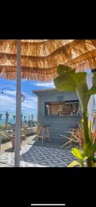 a patio with an umbrella and a table on the beach at Reggae Beach Getaway in Saltdean