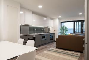 a kitchen with white cabinets and a table and chairs at Aspen - Airport & City Access in Dublin +4 photos