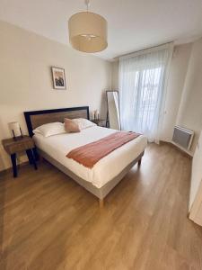 a bedroom with a large bed and a large window at Domitys Les Châtaigniers in Panazol