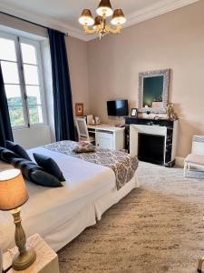 a bedroom with a large bed and a fireplace at Château Hôtel Edward 1er in Monpazier
