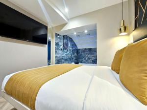 een slaapkamer met een groot bed en een tv bij Hotel London in Londen