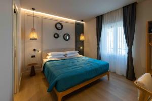 a bedroom with a bed with blue sheets and a window at Gran Suite Darsena in Isola Sacra
