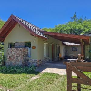 a small house with a porch and a fence at die lavendel chalet in Villa General Belgrano