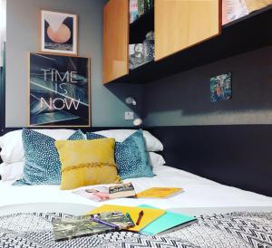 a bed with books and books on top of it at Aspen - Airport & City Access in Dublin