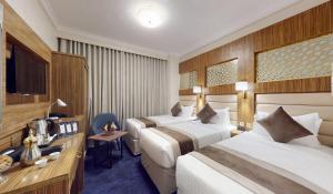 Ένα ή περισσότερα κρεβάτια σε δωμάτιο στο Al Ansar Platinum Hotel فندق الأنصار بلاتينوم