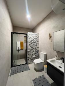 a bathroom with a shower and a toilet and a sink at Maison Aria in Madina