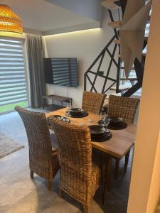 een eetkamer met een houten tafel en stoelen bij TINY HOUSE domek do wynajęcia in Olsztyn