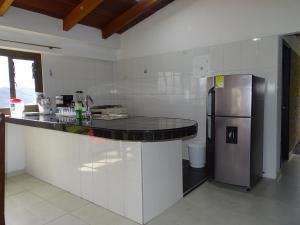 a kitchen with a counter and a refrigerator at Cabaña Campestre Bellavista in Paipa